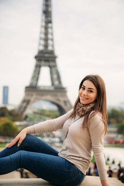 Kaunis nainen on rajalla Eiffel-tornin edessä. Lady hymy ja pitää hauskaa
 - Valokuva, kuva