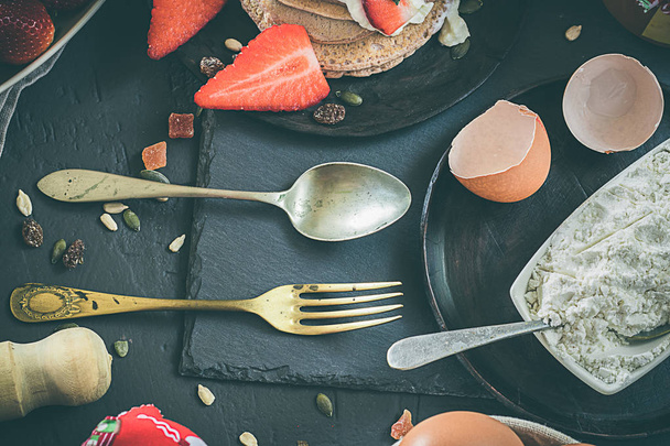 イチゴとヨーグルトのパンケーキ。健康的な朝食用食品を設定します。黒と素朴な背景 - 写真・画像