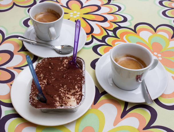 Dessert food still-life of two coffee cups and tiramisu sweet chocolate cake - Photo, Image