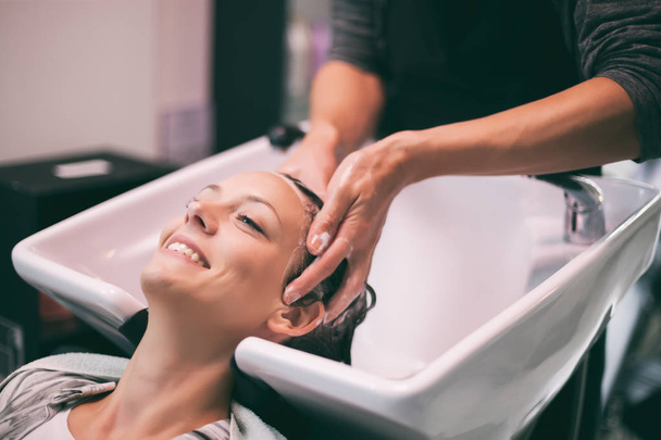 Jovem mulher recebendo novo penteado no salão de cabeleireiro profissional
. - Foto, Imagem