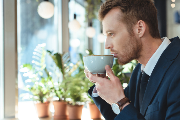 side view of stylish businessman having coffee break in cafe - Photo, Image