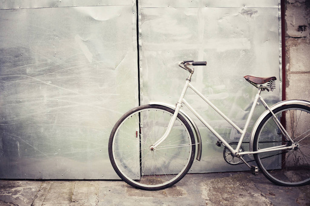 vintage bicycle standing against grey wall - Foto, afbeelding