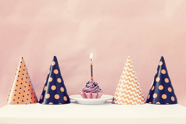 Birthday cake with candle and cone hats in vintage color, copy space - Fotoğraf, Görsel