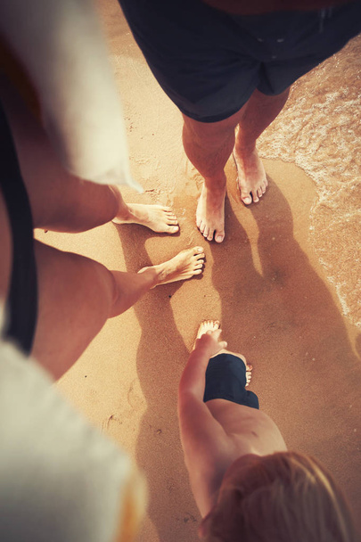 Sahilde deniz suyu tarafından kıyı kum üzerinde aile bacaklar yüksek açılı görünüş - Fotoğraf, Görsel