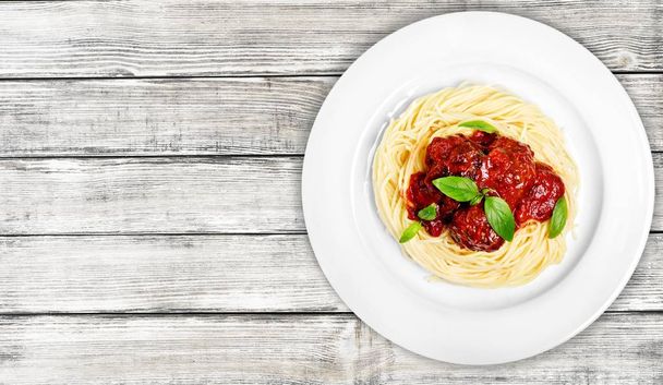 Spaghetti pasta with tomatoes on wooden table  - Foto, afbeelding