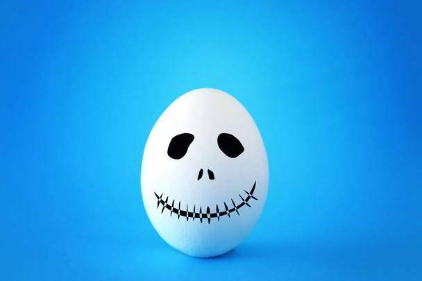 minimal and funny Halloween holiday concept. white egg with scary cute face - Foto, immagini