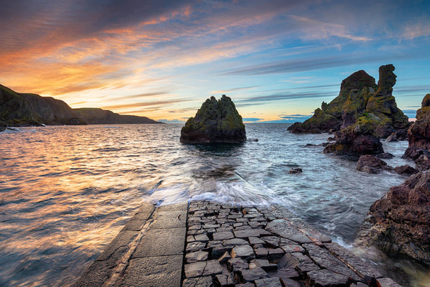 Sunset at the old jetty at Pettico Wick Bay on St Abbs Head near Eyemouth in the Scottish Borders - Photo, Image