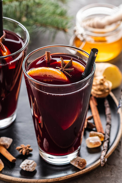 Hot mulled wine with spices, apple and orange on chrictmas background. Copy space. - Фото, изображение