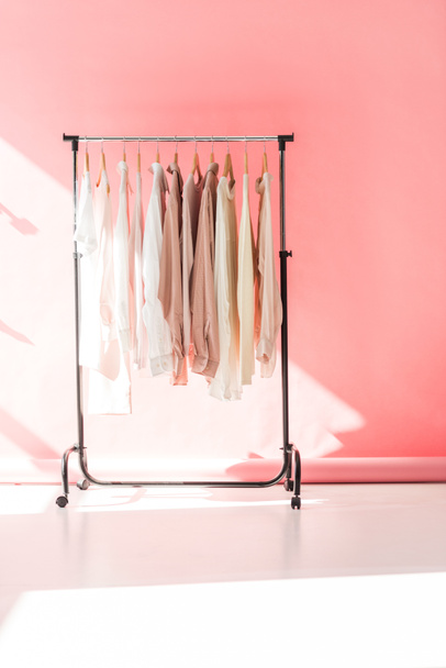 light stylish clothes on hangers in pink boutique - Photo, Image