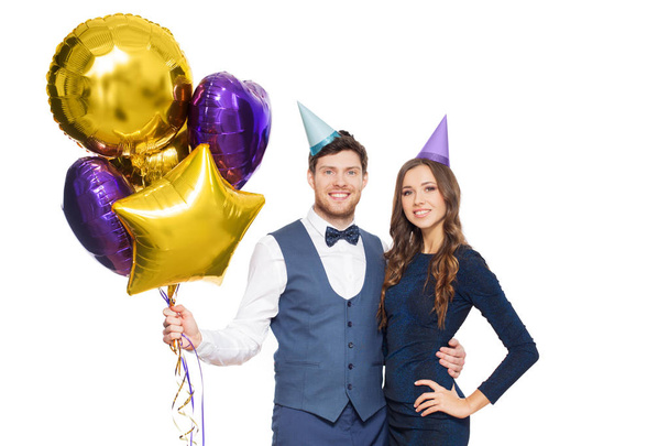 happy couple with party caps and balloons - Foto, Imagen