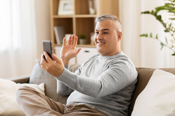 man having video chat on smartphone at home - Фото, зображення