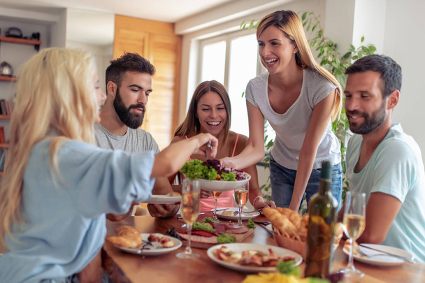 Група друзів, які обідають разом і чудово проводять час вдома
 - Фото, зображення