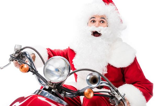 aufgeregten Weihnachtsmann in Kostüm Reiten auf Roller isoliert auf weißem Hintergrund  - Foto, Bild