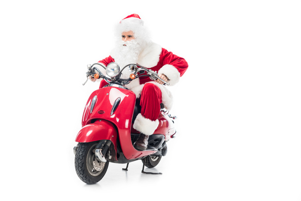 serious santa claus in costume riding on scooter isolated on white background  - Foto, Imagem