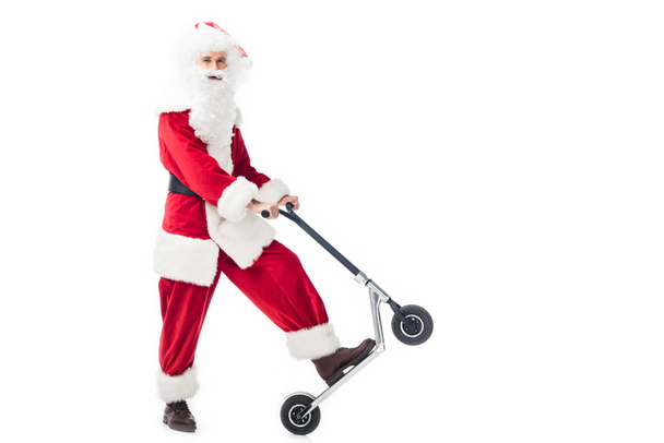 smiling santa claus in costume standing with kick scooter isolated on white background - Photo, image