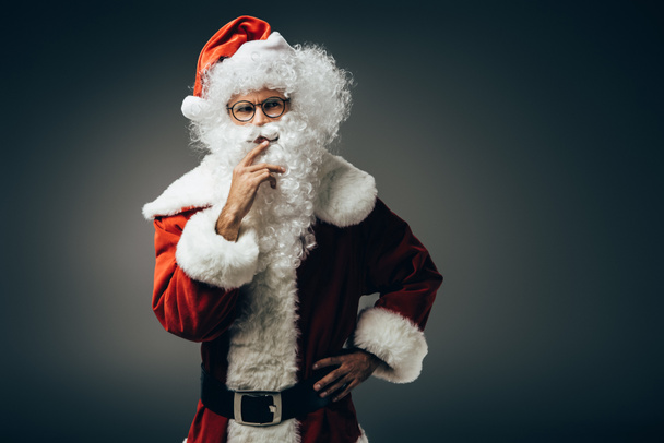 thoughtful santa claus in costume holding hand near mouth isolated on grey background  - Fotó, kép