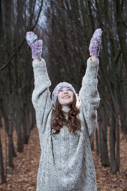 Woman outdoors portrait. Young woman in warm knitted clothes in forest late autumn scenery. First snow concept - Photo, image