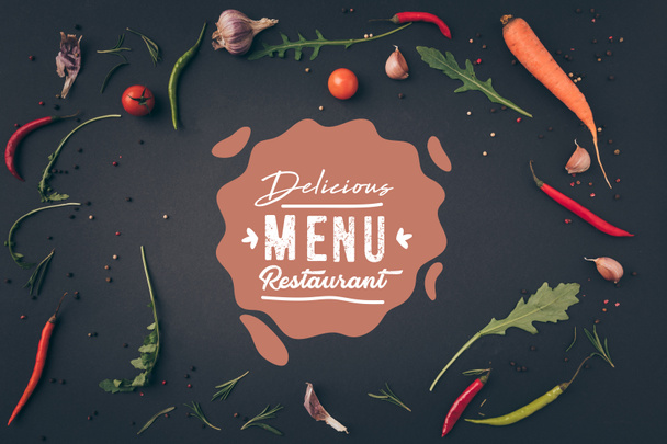 vista superior de rúcula, zanahoria y chiles en la superficie gris con letras de "delicioso restaurante de menú"
  - Foto, Imagen