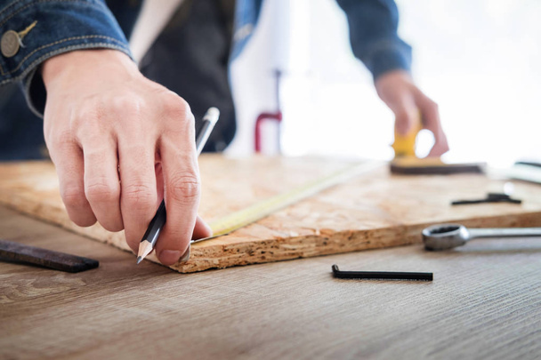Marangoz, marangozluk planları eser dikkatle bakarak çalışma. Onun işyerinde başarılı bir girişimci olduğunu. Destekler üzerinde inşaat alanında iş kesici ile çivi çekiç - Fotoğraf, Görsel