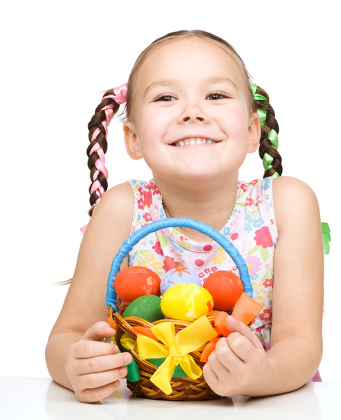 Little girl with basket full of colorful eggs - Foto, Imagem