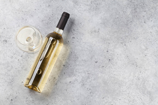 Weißweinflasche und Glas auf Steinkulisse liegend. Ansicht von oben mit Platz für Ihren Text - Foto, Bild