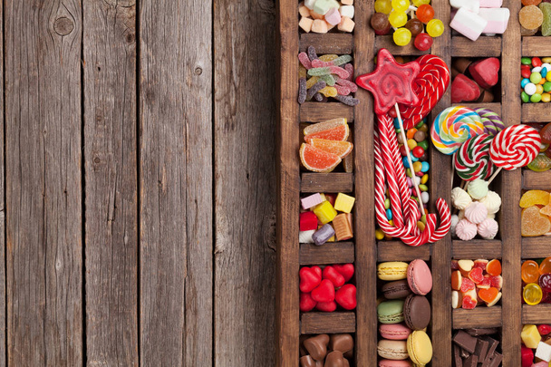 Caixa de doces coloridos. Pirulitos, macaroons, marshmallow, marmelada e doces. Vista superior com espaço para suas saudações
 - Foto, Imagem