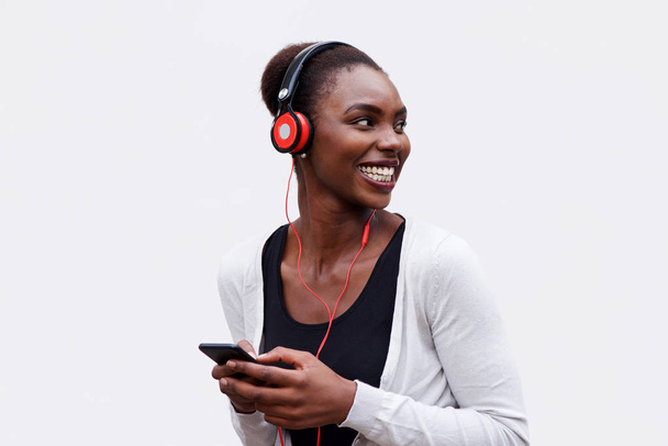 Retrato de mulher americana africana feliz ouvindo música com fones de ouvido e telefone celular
 - Foto, Imagem