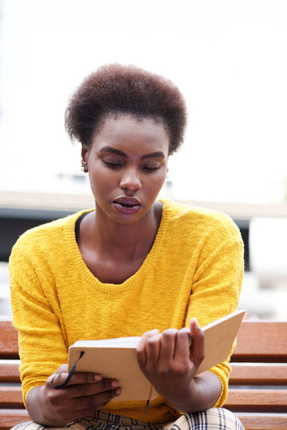 Muotokuva afrikkalainen amerikkalainen nainen lukee kirjaa penkki ulkona
 - Valokuva, kuva