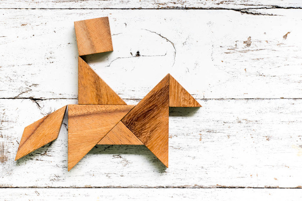 Puzzle tangram en forme de cheval de promenade homme sur fond vieux bois blanc
 - Photo, image