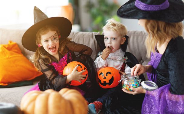 Feliz Halloween! una madre trata a los niños con dulces en hom
 - Foto, imagen