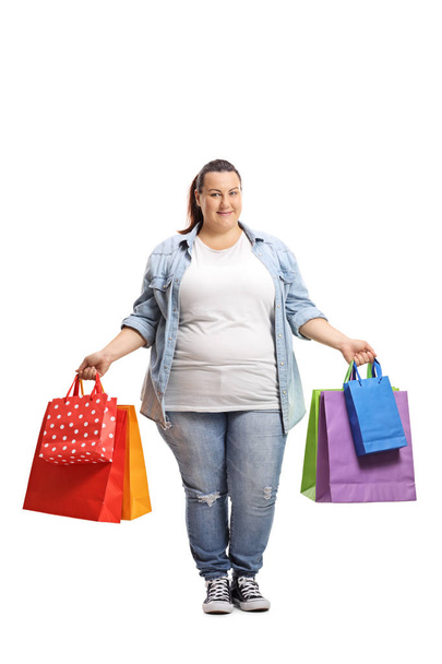 Full length portrait of a young woman with shopping bags isolated on white background - Fotografie, Obrázek