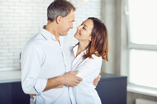 Mature couple happy hugging indoors. - Fotó, kép