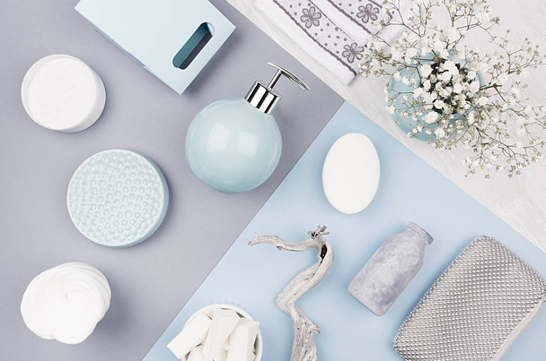 Cosmetics products as art background - set for body and skin care, blue ceramic bowl, silver accessories, flowers on white wood and pastel blue, grey paper, top view. - Foto, immagini