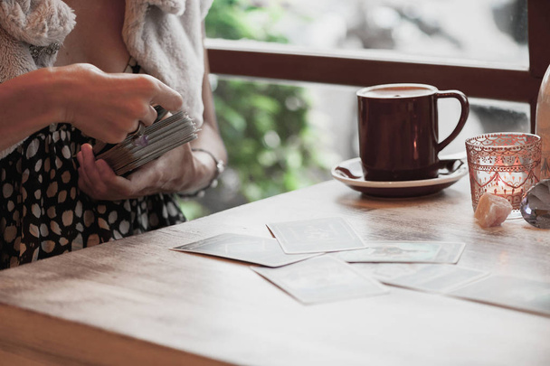 Femme lit des cartes de tarot sur la table dans un café - Photo, image