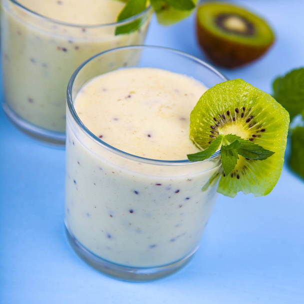 Smoothies with a banana and kiwi on a blue wooden table. Delicious dessert. - Foto, Bild