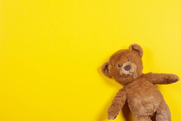 Teddy bear toy on yellow background. Top view - Photo, Image