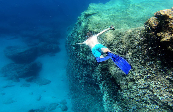 Snorkeling man swimming underwater in blue sea water - Fotoğraf, Görsel