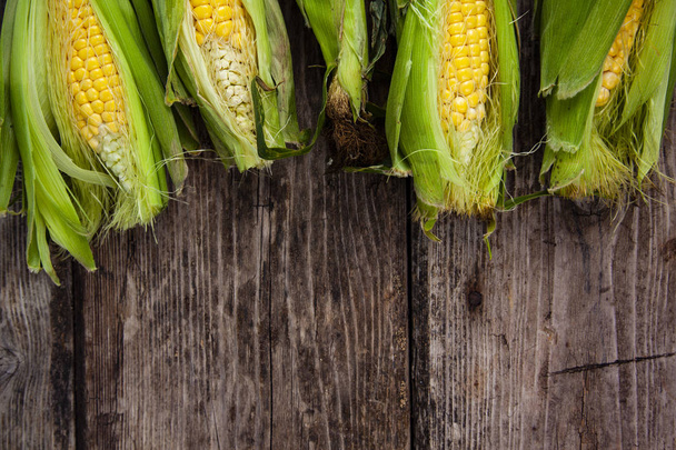 Ripe corn on an old wooden table. - Foto, afbeelding