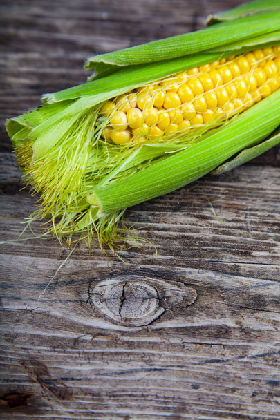 Ripe corn on an old wooden table. - Foto, afbeelding