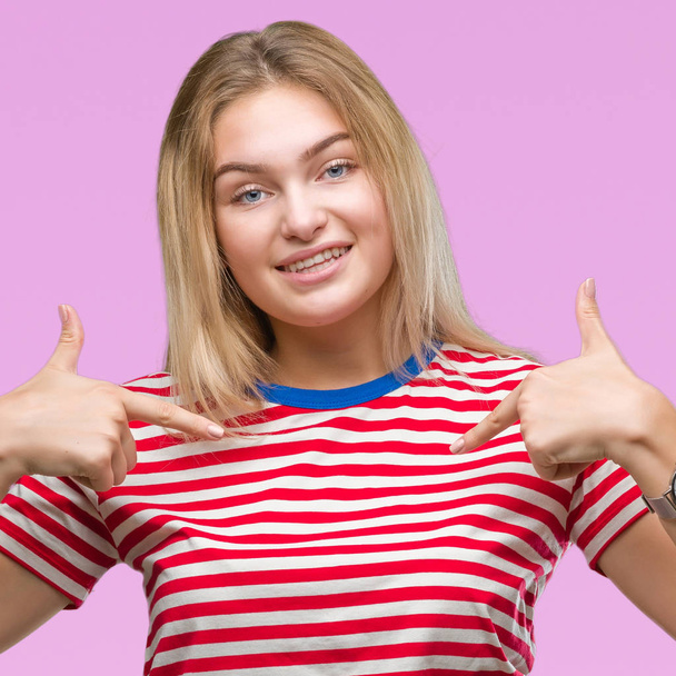 Young caucasian woman over isolated background looking confident with smile on face, pointing oneself with fingers proud and happy. - Фото, зображення