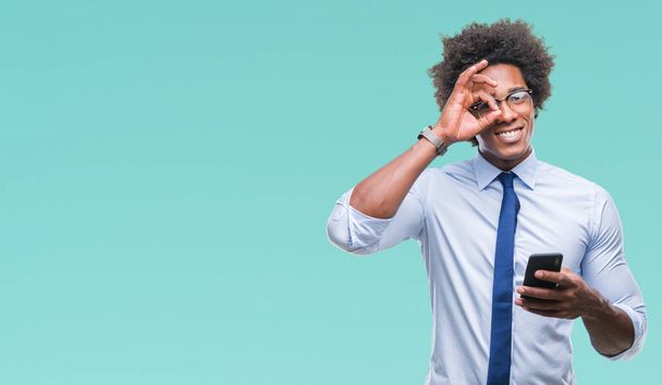 Afro american business man texting using smartphone over isolated background with happy face smiling doing ok sign with hand on eye looking through fingers - Photo, Image