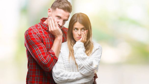 Young couple in love wearing winter sweater over isolated background thinking looking tired and bored with depression problems with crossed arms. - Photo, Image