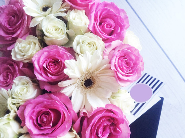 Λουλούδια σε ένα κουτί τριαντάφυλλα και πολύχρωμα μακαρόν μακαρόνια marshmallow βαμβάκι - Φωτογραφία, εικόνα