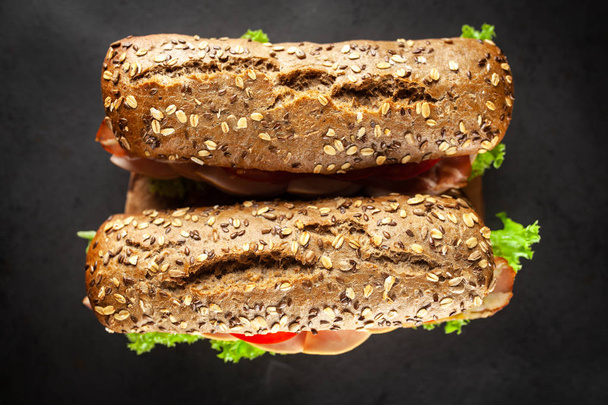 Класичні бутерброди BLT на темному фоні
 - Фото, зображення