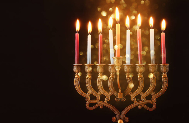Low key Image of jewish holiday Hanukkah background with menorah (traditional candelabra) and burning candles - Foto, afbeelding