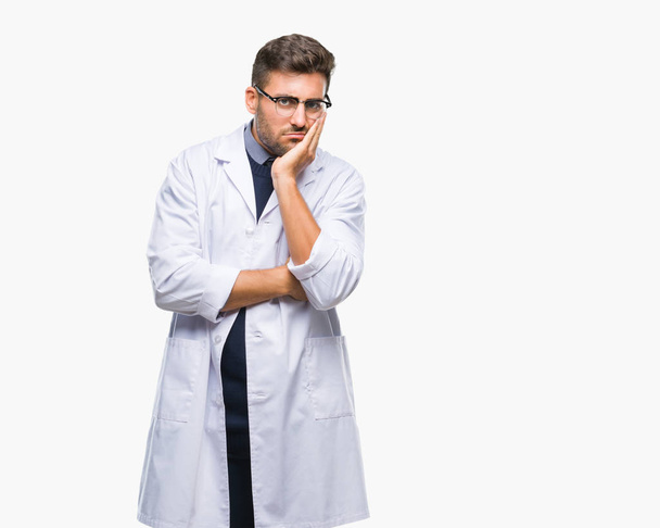 Mladý pohledný muž nosí doktor, scientis kabát nad izolované pozadí myšlení pohledu unavený a znuděný s depresi problémy s překřížením rukou. - Fotografie, Obrázek