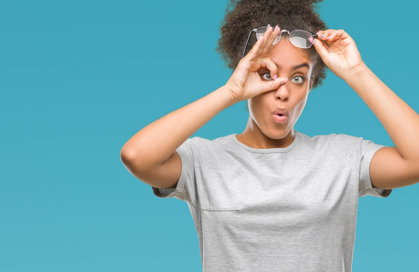 眼鏡をかけて ok のジェスチャーを行う分離の背景に若いアフロ ・ アメリカ人女性は、驚いた顔で、指を通して見る目ショックを受けた。疑うような式. - 写真・画像