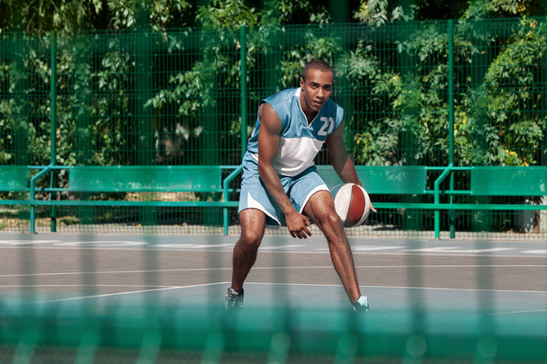 Picture of young confused african basketball player practicing - Photo, image