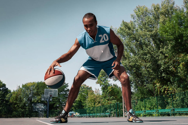 Picture of young confused african basketball player practicing - 写真・画像