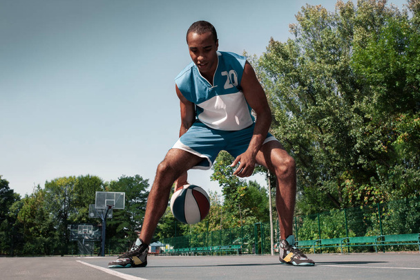 Picture of young confused african basketball player practicing - Foto, imagen